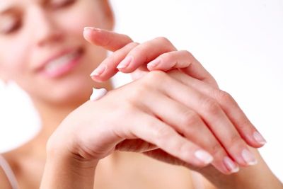 Frau cremt sich die Hände mit Propolis-Creme ein